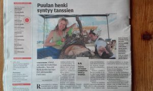 Newspaper article on Sanna Karlsson-Sutisna creating the public sculpture Puulan henki during an artist residency in Kangasniemi, with the finished work dedicated to the municipality's 150th anniversary.