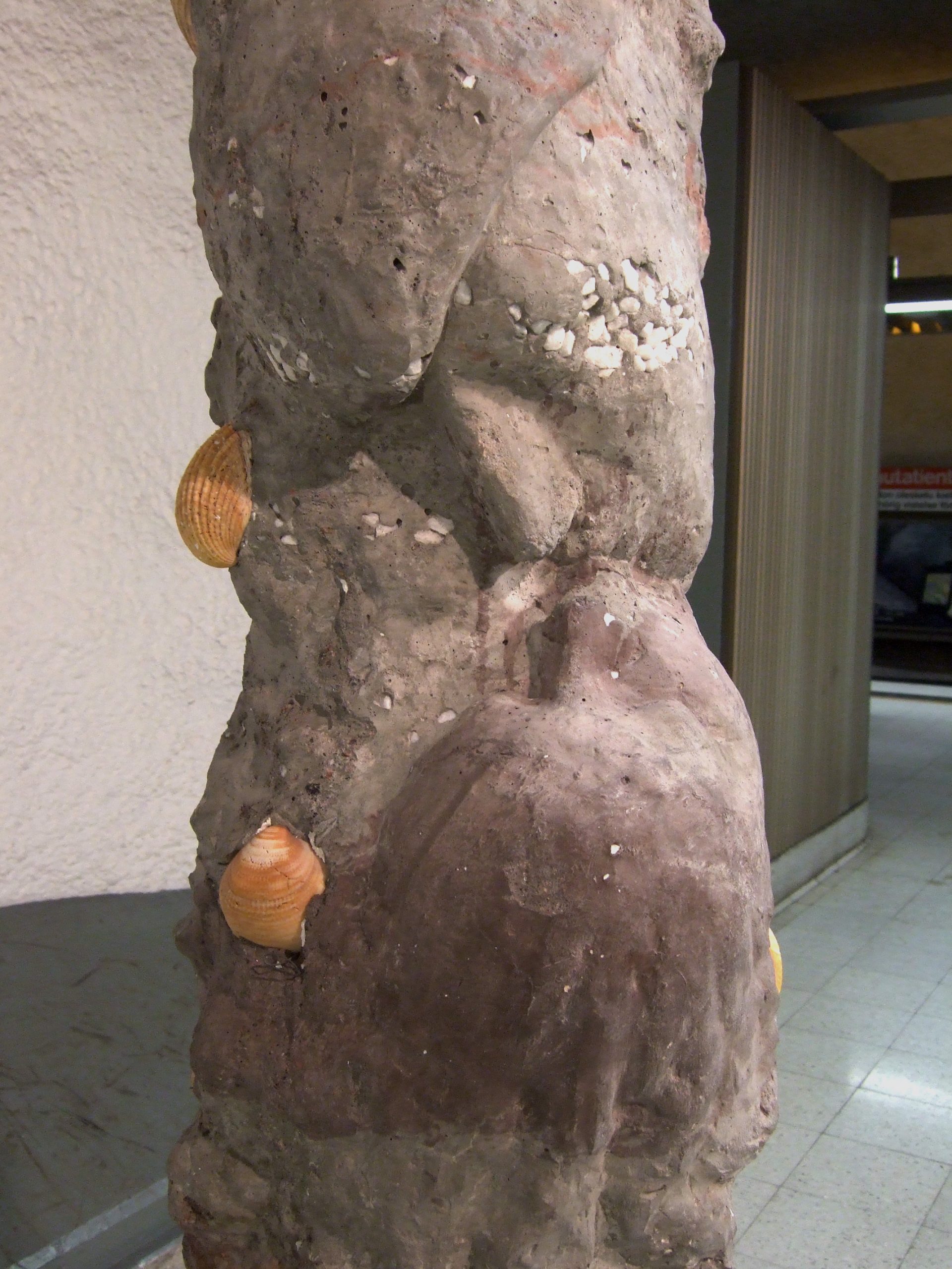 Public artwork Faces In The Metro concrete sculpture installation, rear view of a concrete face sculpture with embedded seashells at Helsinki Central Railway Metro station, 2007.