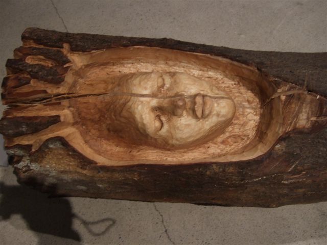 Close-up of a carved human face in a wooden log sculpture by Sanna Karlsson-Sutisna, from the Iroko exhibition at EMMA – Espoo Museum of Modern Art, 2010.