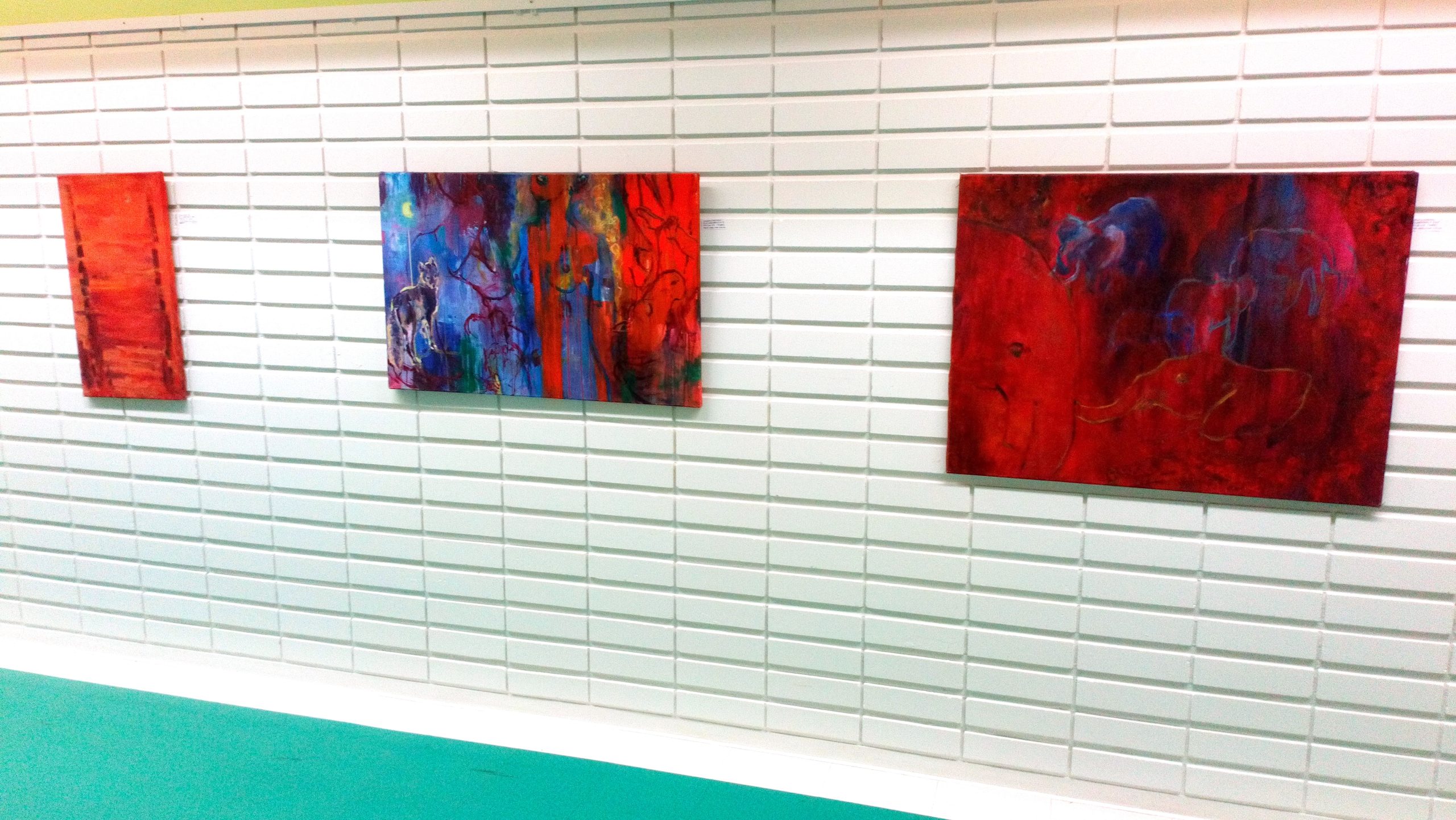 Encounter - Exhibition by Sanna Karlsson-Sutisna - Three red and blue abstract paintings on a white-tiled corridor wall. - Jorvi hospital 2019.