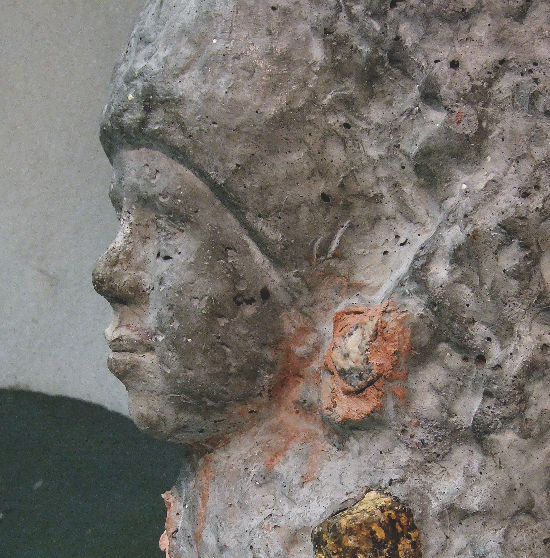 Public artwork Faces In The Metro concrete sculpture installation, profile close-up of a concrete face with textured surface at Helsinki Central Railway Metro station, 2007.