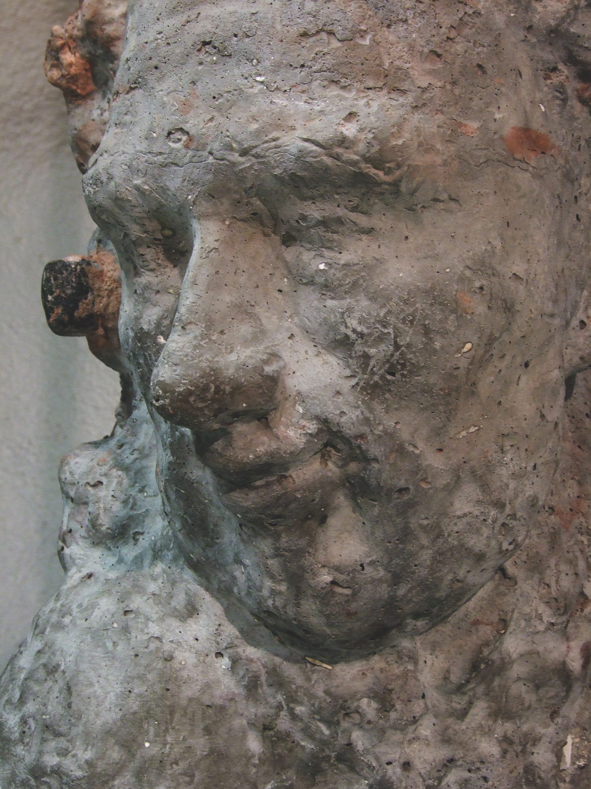 Public artwork Faces In The Metro concrete sculpture installation, close-up of a sculpted human face in profile at Helsinki Central Railway Metro station, 2007.